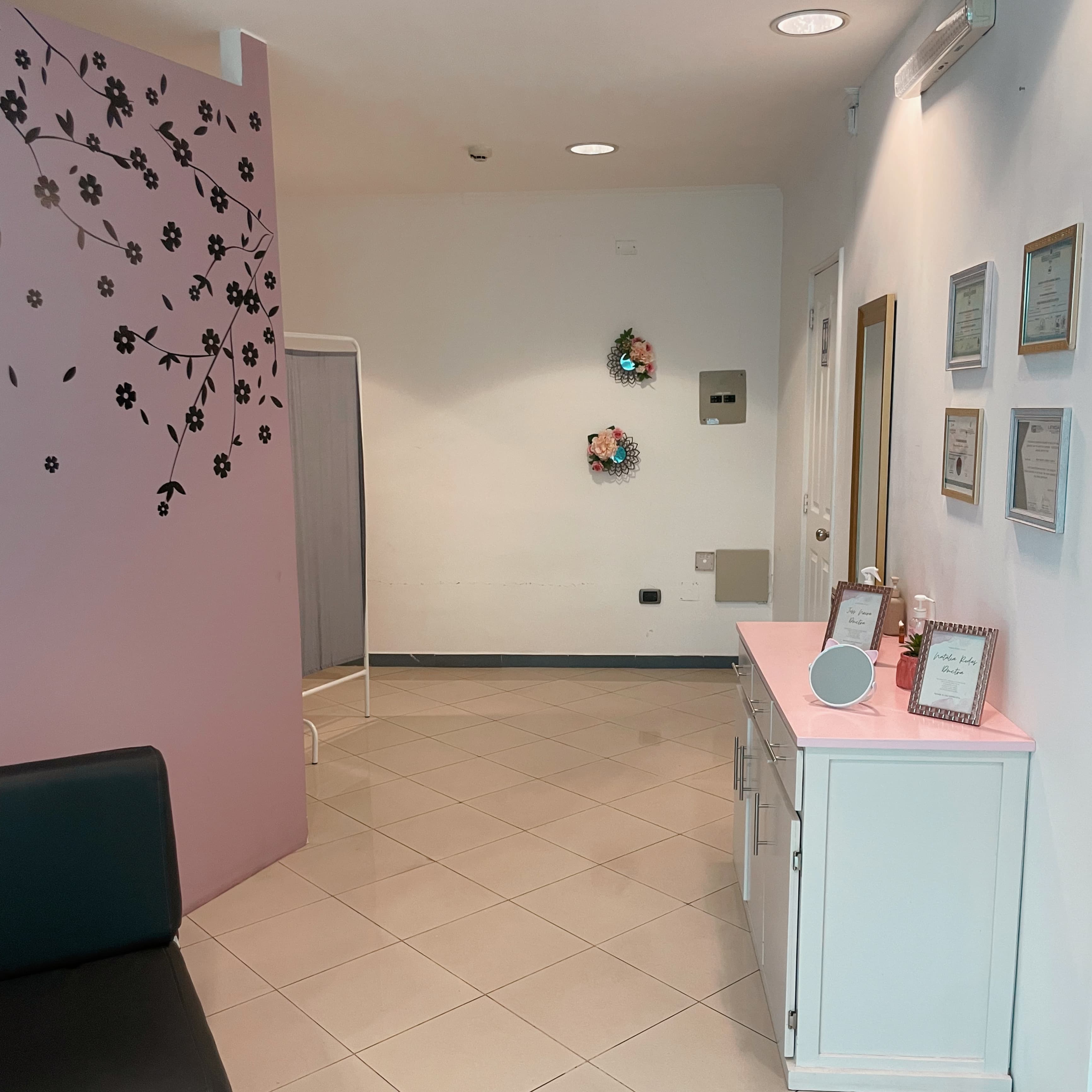 Area de espera con pared decorativa floral y certificaciones